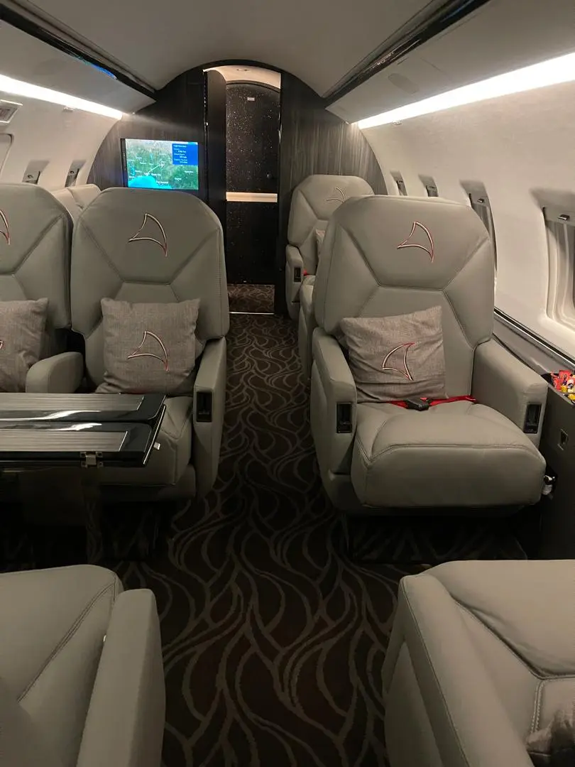 Private jet cabin interior with in-flight route map on cabin display