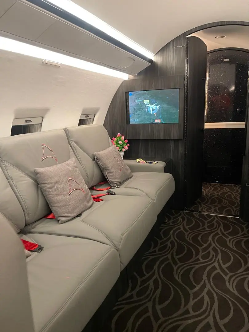 Private jet cabin lounge seating with fresh flowers