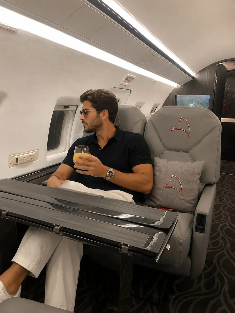 Passenger served fresh orange juice aboard a private jet cabin